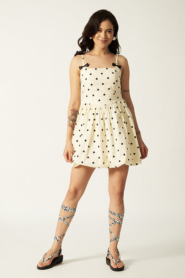 Woman wearing a polka dot dress with a plain background